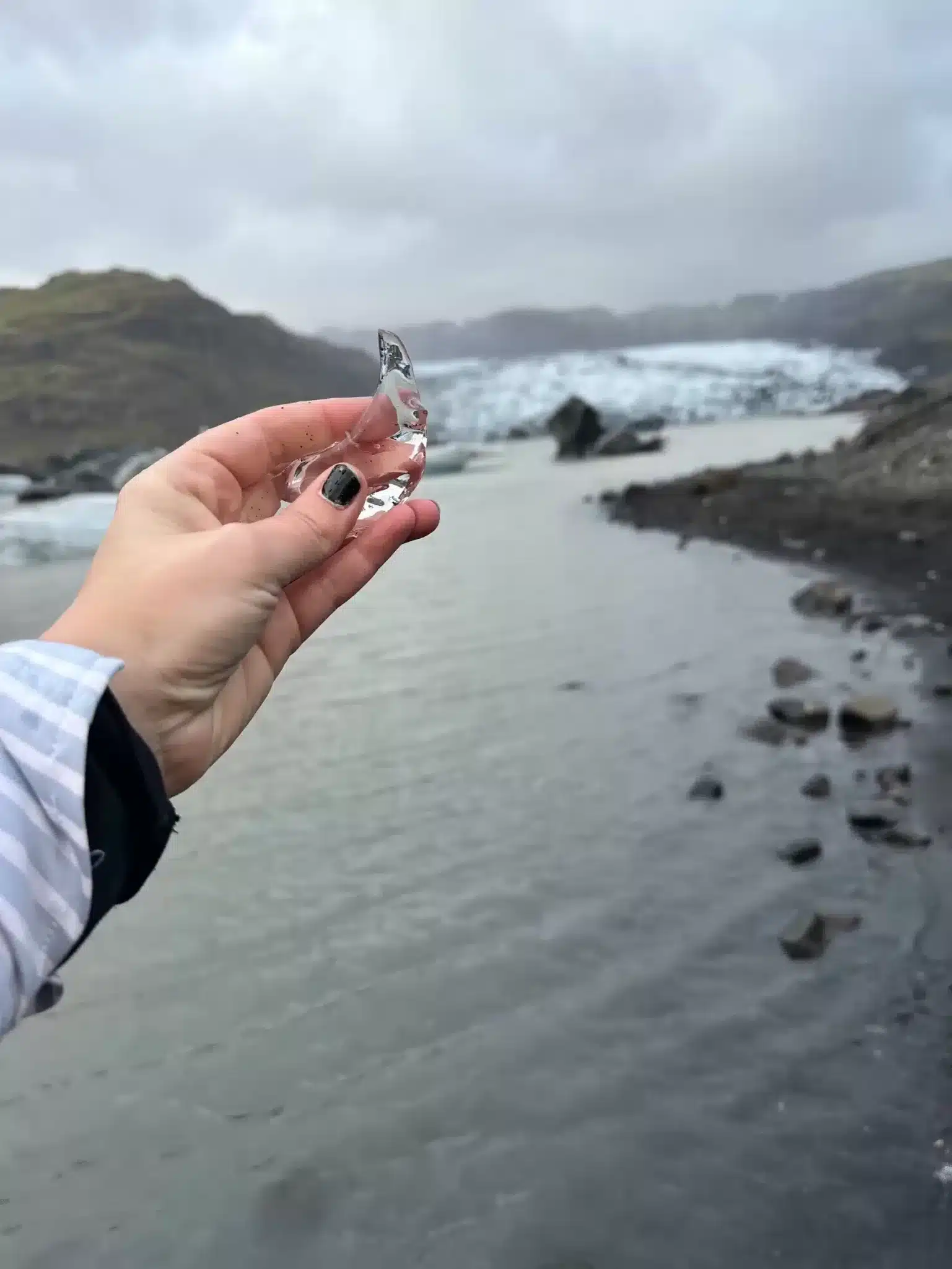 Holding a piece of glacier along the South Coast in Iceland, a stop that can be seen on the map in my travel itinerary.